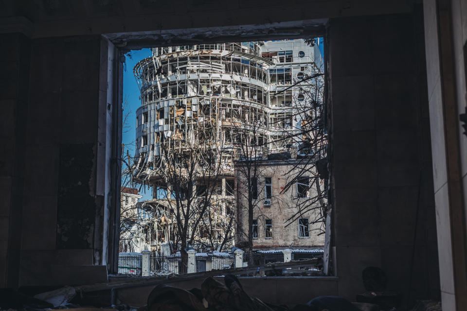 A wrecked office building framed by a blown-out window.