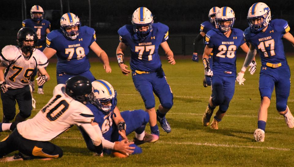 Mt. Markham Mustang Hunter Makuch (69) pounces on a loose ball and recovers a Notre Dame fumble in Friday's season-opening victory.