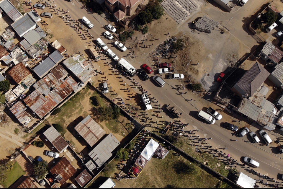 Thousands line up to receive food handouts in the Olievenhoutbos township of Midrand, South Africa, Saturday May 2, 2020. though South Africa begun a phased easing of its strict lockdown measures on May 1, its confirmed cases of coronavirus continue to increase. (AP Photo/Jerome Delay)