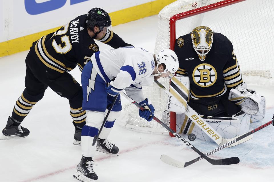 Boston Bruins' Linus Ullmark, right, blocks the puck as Bruins' Charlie McAvoy (73) defends against Tampa Bay Lightning's Brandon Hagel (38) during the first period of an NHL hockey game, Saturday, Jan. 6, 2024, in Boston. (AP Photo/Michael Dwyer)