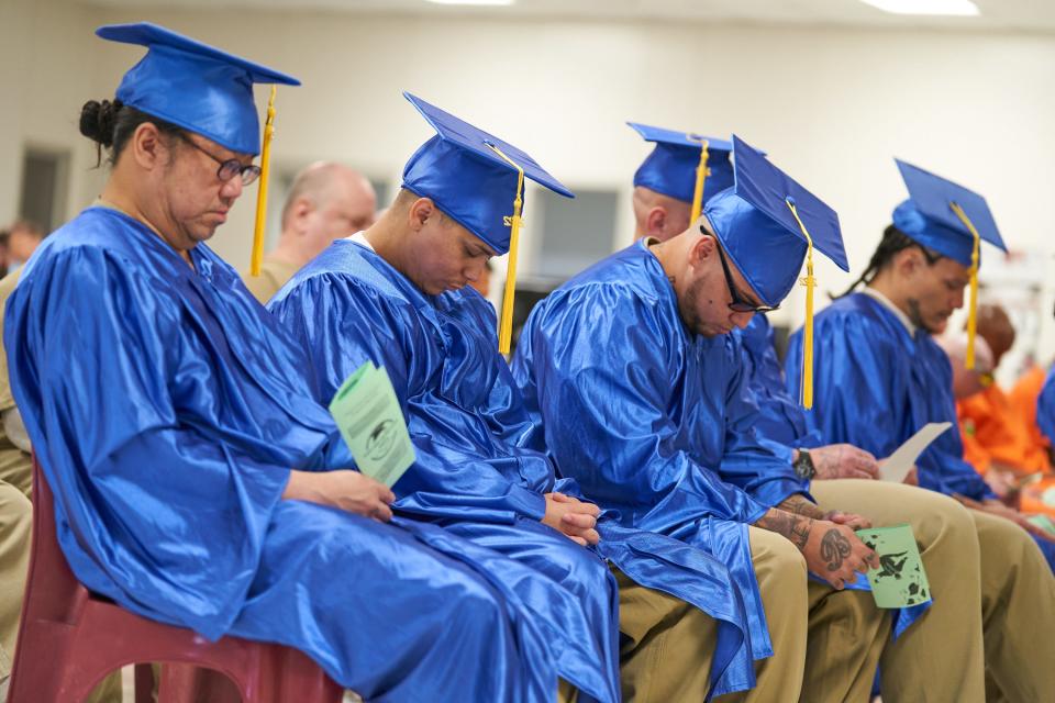 Graduating inmates at the Saguaro Correctional Center in Eloy bow their heads in prayer during their graduation ceremony in Eloy on May 12.