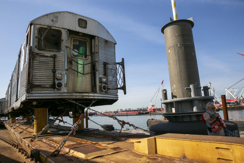 Railroad barge workers offload retired 1960s-era New York City R-32 subway cars at Greenville Yard in Jersey City, N.J., on Wednesday, June 15, 2022. From here, the old subway cars will travel by rail to an Ohio scrapyard as the MTA installs new R-179 train cars into the city's sprawling subway system. (AP Photo/Ted Shaffrey)