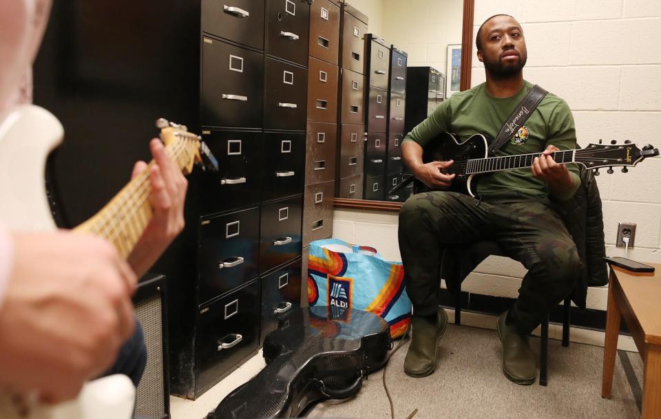 Guitar student Blake Smith listens as Akron jazz guitarist Dan Wilson plays a scale during a lesson in his office in Guzzetta Hall at the University of Akron.