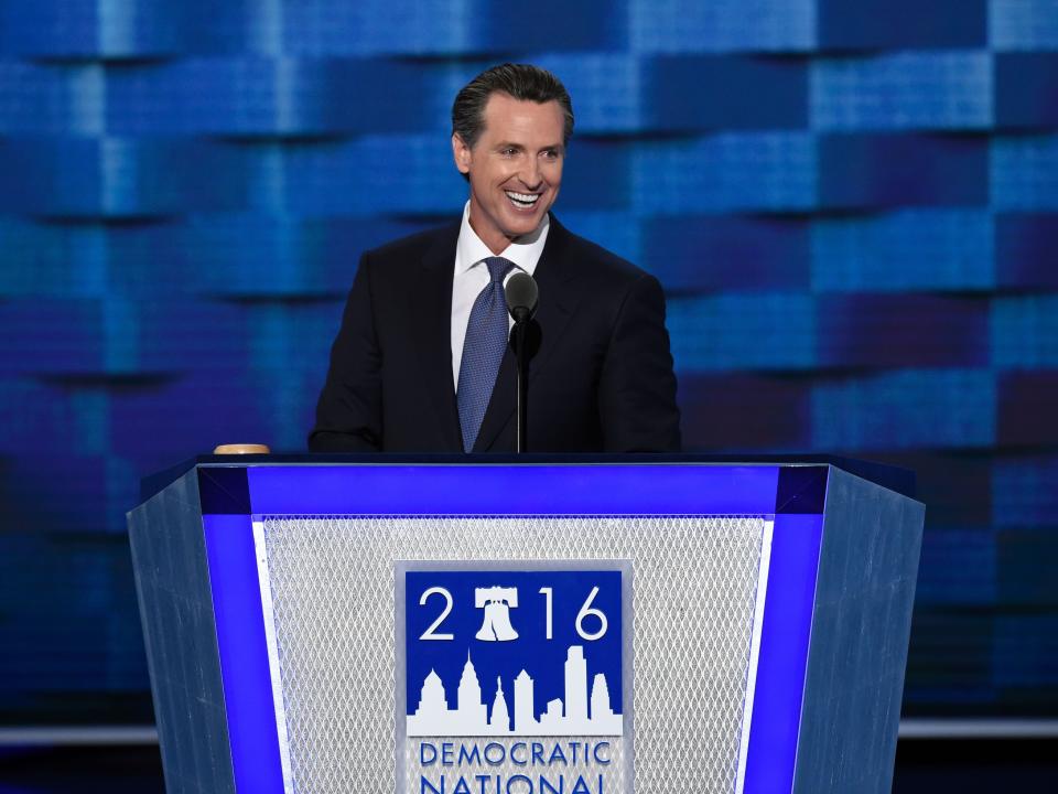 California Lieutenant Governor Gavin Newsom speaks at a podium for the 2016 Democratic National Convention.