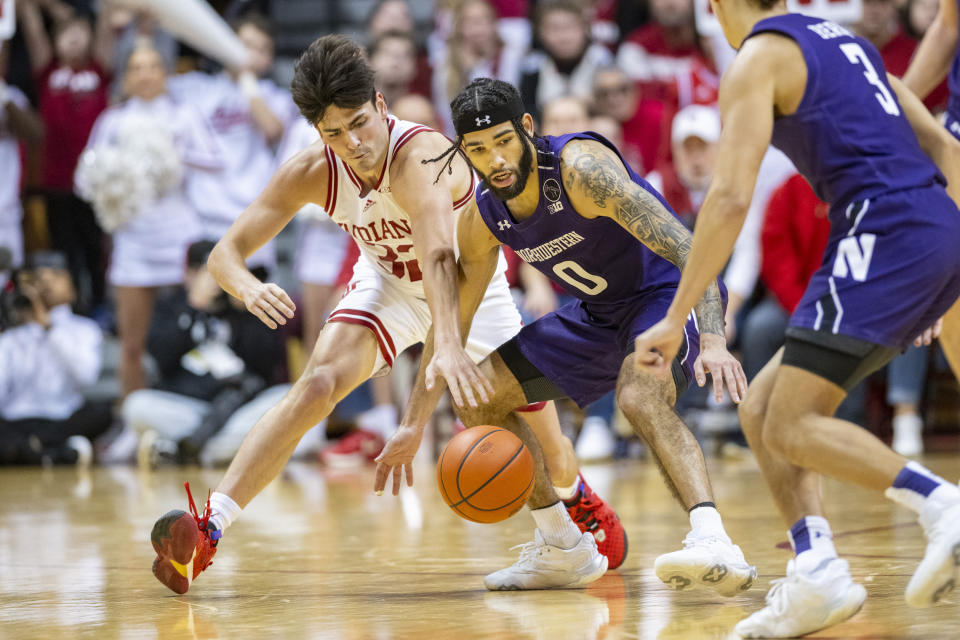 Indiana guard Trey Galloway, left, attempts to steal the ball from Northwestern guard Boo Buie (0) during the second half of an NCAA college basketball game, Sunday, Jan. 8, 2023, in Bloomington, Ind. (AP Photo/Doug McSchooler)