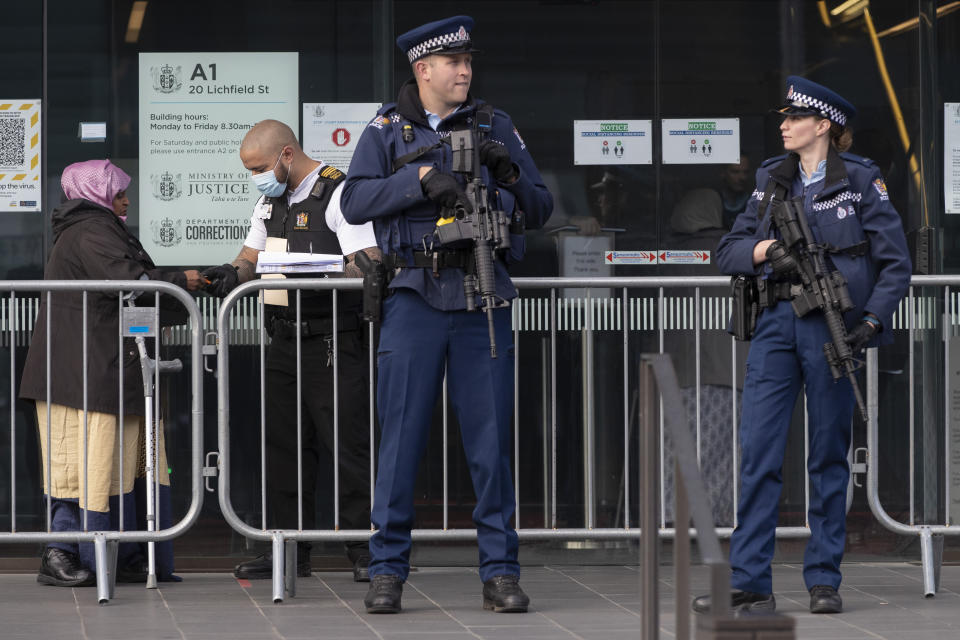 FILE - Armed police officers guard the entrance as family and survivors from the March 2019 Christchurch mosque shootings line up to enter the Christchurch High Court for day two of the sentencing hearing of Australian Brenton Harrison Tarrant, in Christchurch, New Zealand, on Aug. 25, 2020. New Zealand’s government will overhaul the tighter gun laws introduced after a deadly mass shooting by a white supremacist five years ago, because they put excessive burdens on gun owners who feel vilified by law enforcement and the public, the lawmaker leading the changes said. (AP Photo/Mark Baker, File)