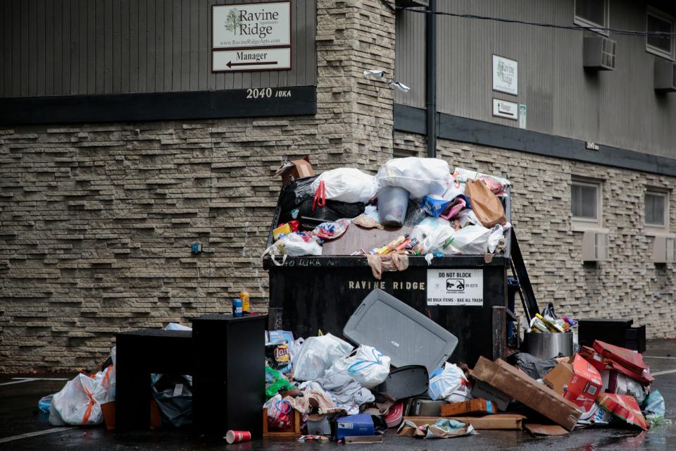 Trash overflows a dumpster near an apartment complex in the University District in 2018. Trash had historically piled up around off-campus housing as students' leases have expired, so the city, University District Organization and university have all worked together to reduce waste and bulk trash.