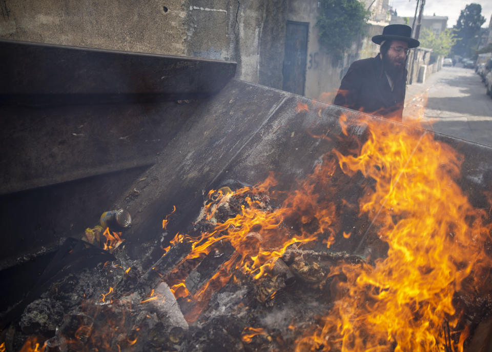 An ultra-Orthodox Jewish man looks on after he burned leavened items in final preparation for the Passover holiday in the Orthodox neighborhood of Mea Shearim in Jerusalem, Wednesday, April 8, 2020. Israeli Prime Minister Benjamin Netanyahu announced Monday a complete lockdown over the upcoming Passover holiday to control the country's coronavirus outbreak, but offered citizens some hope by saying he expects to lift widespread restrictions after the week-long festival. Passover begins on sundown Wednesday. (AP Photo/Ariel Schalit)