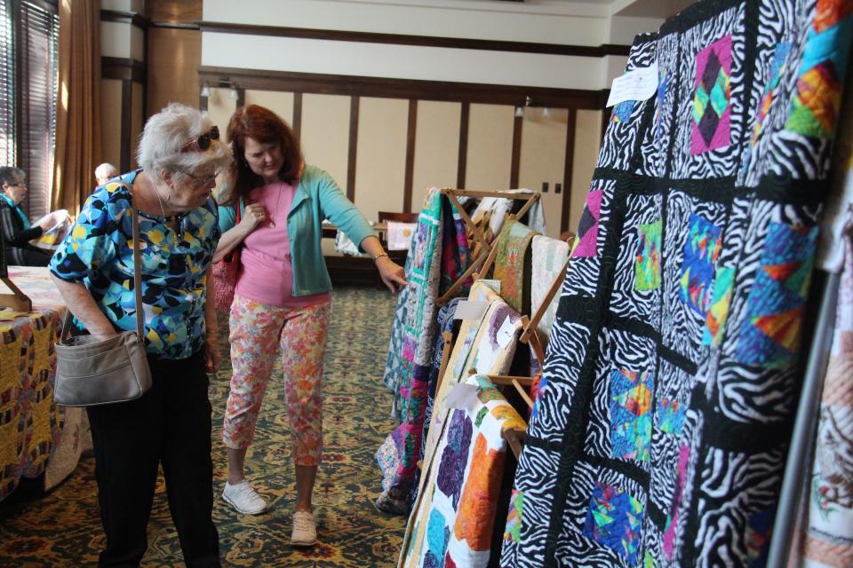 Sue Finer, of Perry, and Ellen Fisher, of Urbandale, check out the quilts on display during the Fiber Festival of Perry on Saturday, May 14, 2022, at the Hotel Pattee.