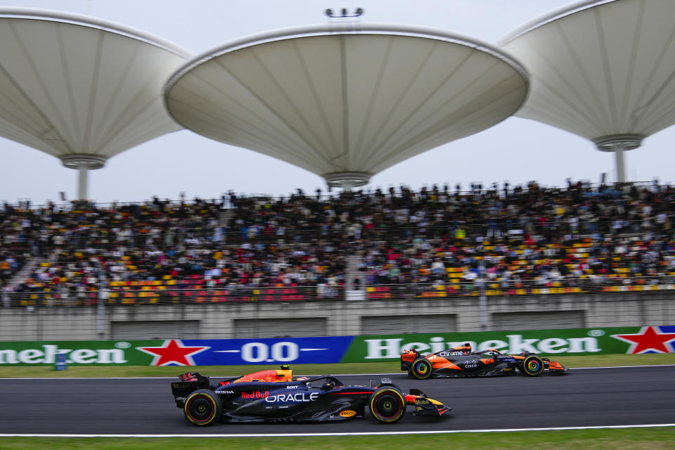 Red Bull driver Sergio Perez, left, of Mexico and McLaren driver Oscar Piastri of Australia steer their cars during the sprint qualifying session for the Chinese Formula One Grand Prix at the Shanghai International Circuit, Shanghai, China, Friday, April 19, 2024. (AP Photo/Andy Wong)