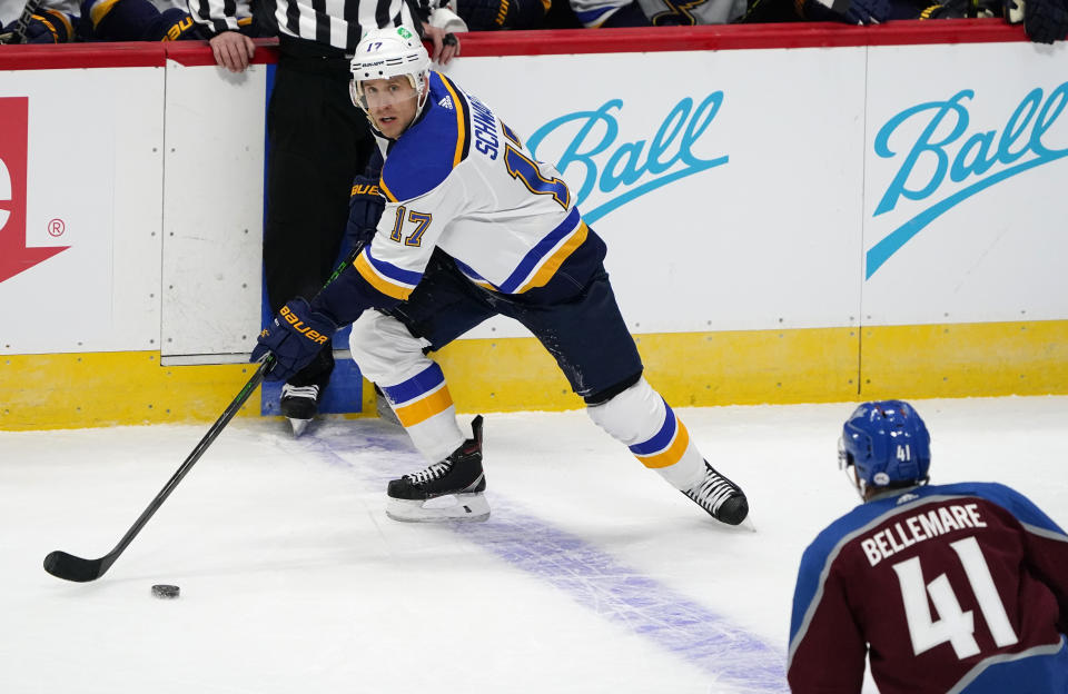 St. Louis Blues defenseman Robert Bortuzzo, back, looks to pass the puck as Colorado Avalanche center Pierre-Edouard Bellemare defends during the first period of an NHL hockey game Wednesday, Jan. 13, 2021, in Denver. (AP Photo/David Zalubowski)