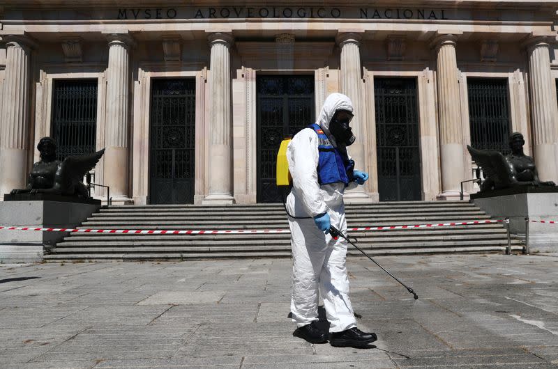 A member of the Spanish Emergency Military Unit (UME) wearing a full personal protective equipment disinfects outside the Archaeological Museum in Madrid