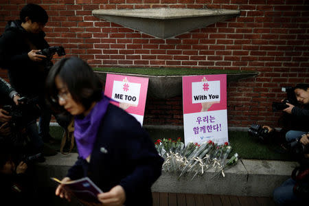 Flowers are placed in front of placards during a protest as a part of the #MeToo movement on International Women's Day in Seoul, South Korea, March 8, 2018. REUTERS/Kim Hong-Ji