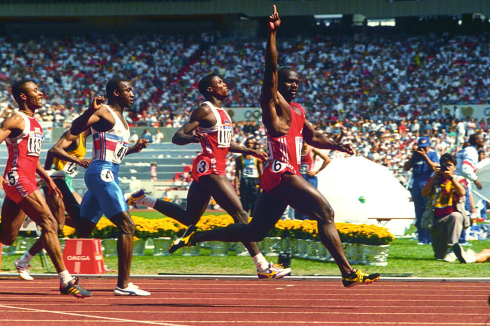 Ben Johnson raises an arm during Olympics race