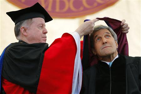 United States Secretary of State John Kerry ducks as he receives an honorary Doctor of Laws degree from college president William Leahy (L) during Commencement Exercises at Boston College in Boston, Massachusetts May 19, 2014. REUTERS/Brian Snyder