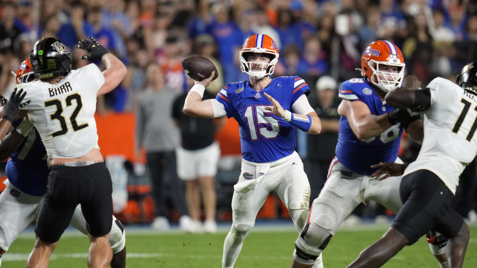 Florida quarterback Graham Mertz (15) throws a pass as Central Florida linebacker Ethan Barr (32) and defensive end Nyjalik Kelly (11) try to defend during the first half of an NCAA college football game, Saturday, Oct. 5, 2024, in Gainesville, Fla. (AP Photo/John Raoux)