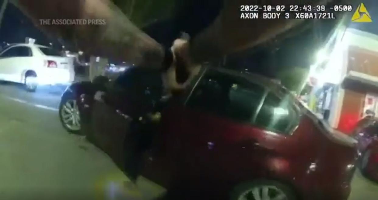 This screenshot from bodycam footage shows a Texas police officer shoot a teenager who was sitting in his car eating a hamburger.