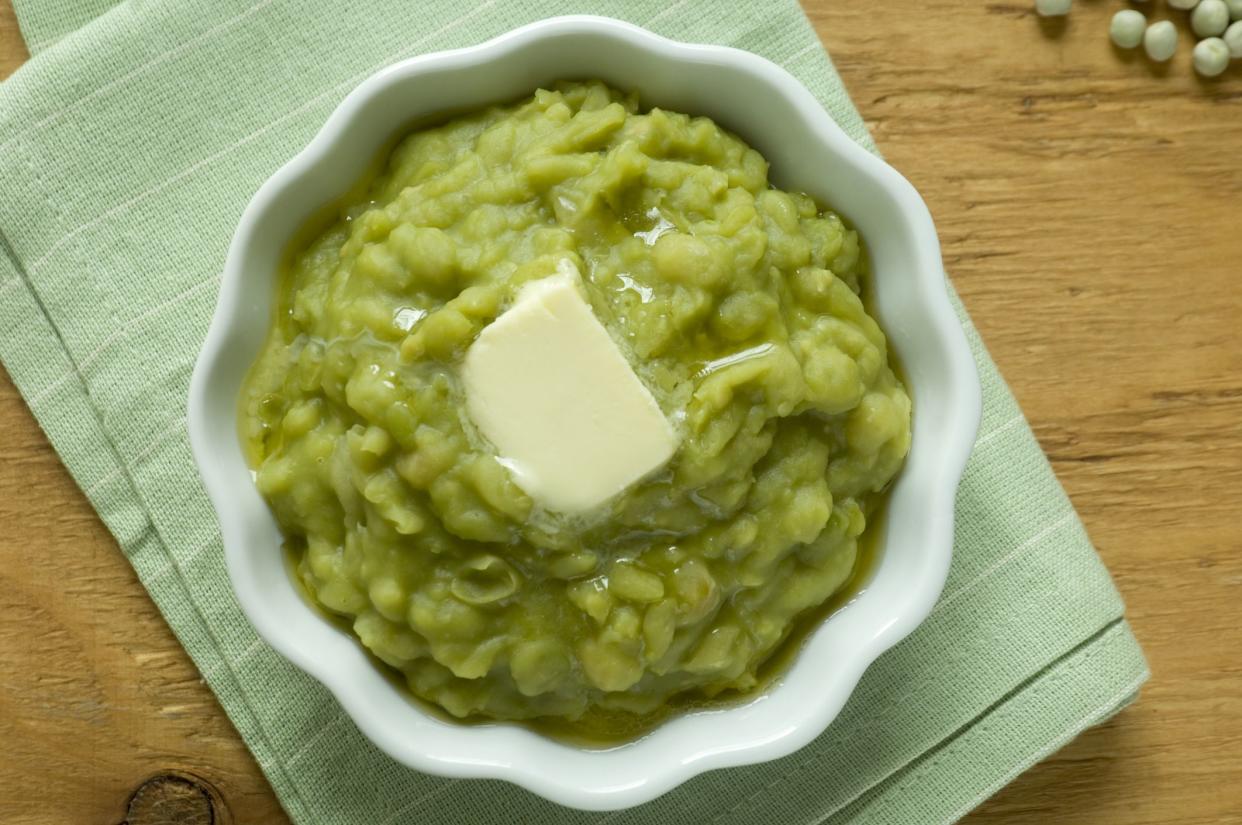 An overhead shot of homemade mushy peas with a knob of butter melting on the top.