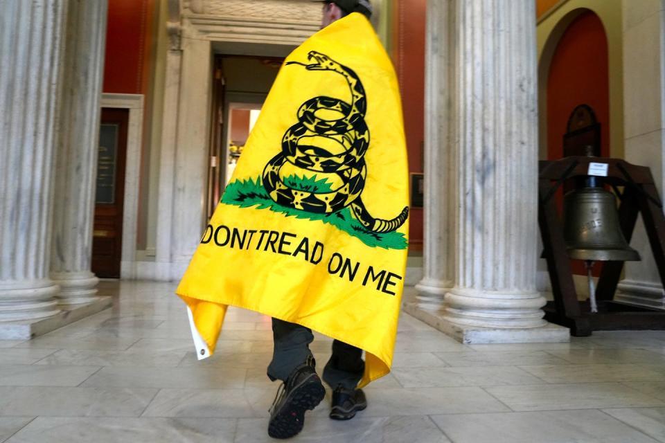 A gun rights supporter walks through the State House hallways on Monday afternoon as gun control advocates and gun rights supporters gathered to testify on an array of gun bills before the House Judiciary Committee.