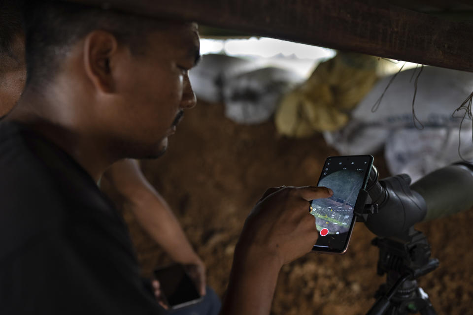 A Meitei community member monitors the positions of rival tribal Kuki community bunkers at a de facto frontline which dissect the area into two ethnic zones in Sugnu, the northeastern Indian state of Manipur, Wednesday, June 21, 2023. The two warring factions have formed armed militias, laying bare the ethnonationalist fissures that have long threatened to worsen instability in India's restive northeastern region. (AP Photo/Altaf Qadri)