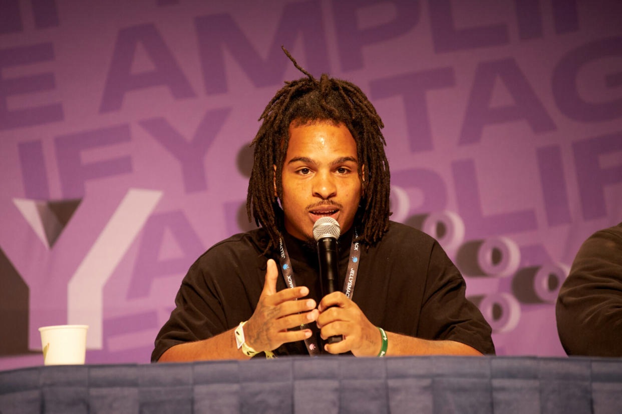 Keith Lee speaking into microphone at a conference