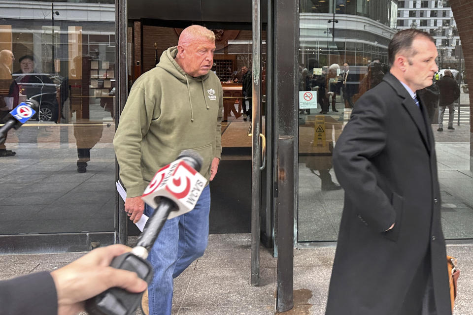 Massachusetts State Police Sgt. Gary Cederquist, center, leaves federal court. Tuesday, Jan 30, 2024, in Boston. Cederquist, 58, of Stoughton, and five others have been charged Tuesday in a scheme to allegedly take bribes including a new snowblower and driveway in exchange for giving passing scores on commercial driving tests, the U.S. attorney’s office said Tuesday. (AP Photo/Michael Casey)