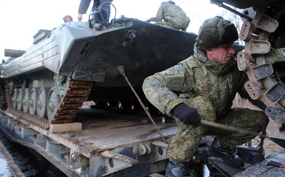 Russian servicemen preparing military vehicles to unload from a troop train for the joint drills in Belarus - AFP