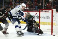 Arizona Coyotes goaltender Antti Raanta, right, makes a save on a shot by Tampa Bay Lightning left wing Ondrej Palat (18) as Coyotes center Christian Dvorak (18) defends during the second period of an NHL hockey game Saturday, Feb. 22, 2020, in Glendale, Ariz. (AP Photo/Ross D. Franklin)