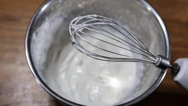 whisk with bowl of whipped cream