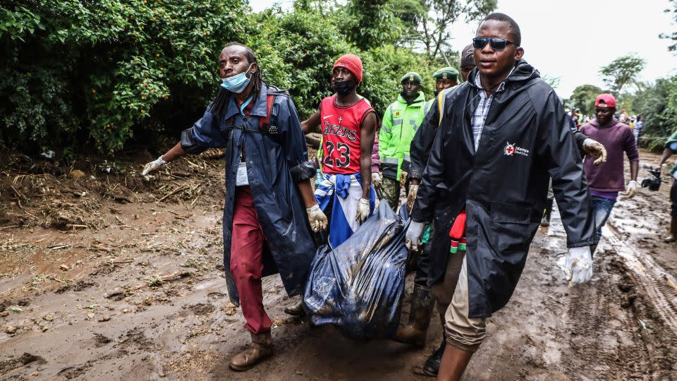 Rescuers carry the body of a young man recovered in the debris following flooding, in Mai Mahiu, Kenya. - James Wakibia/SOPA Images/LightRocket via Getty Images