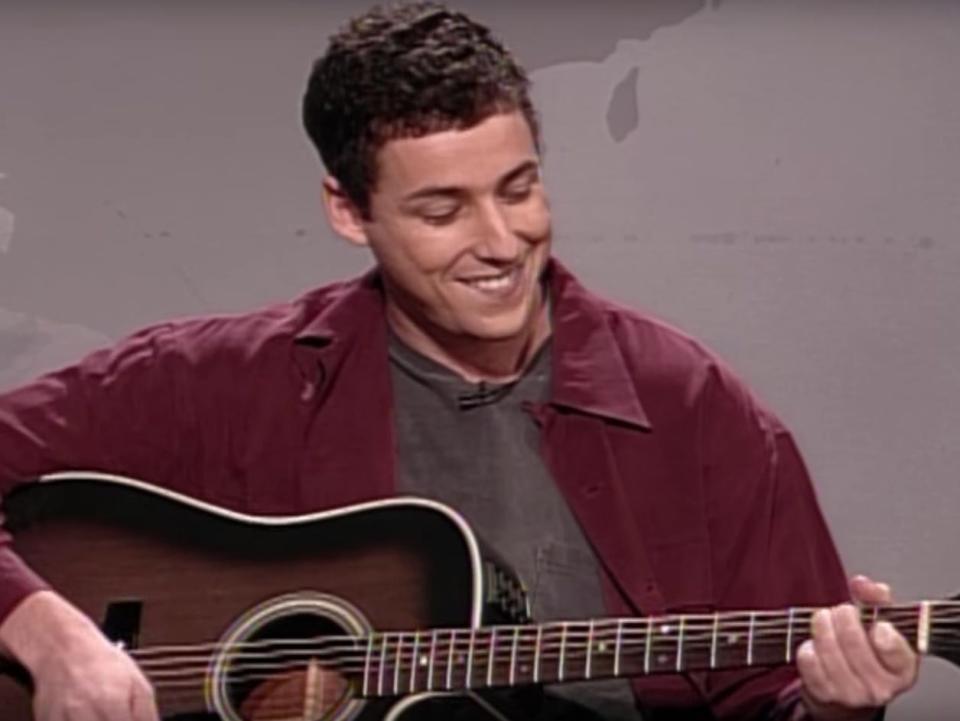 A screenshot in which Adam Sandler sings his famous Hanukkah song on Saturday Night Live.
