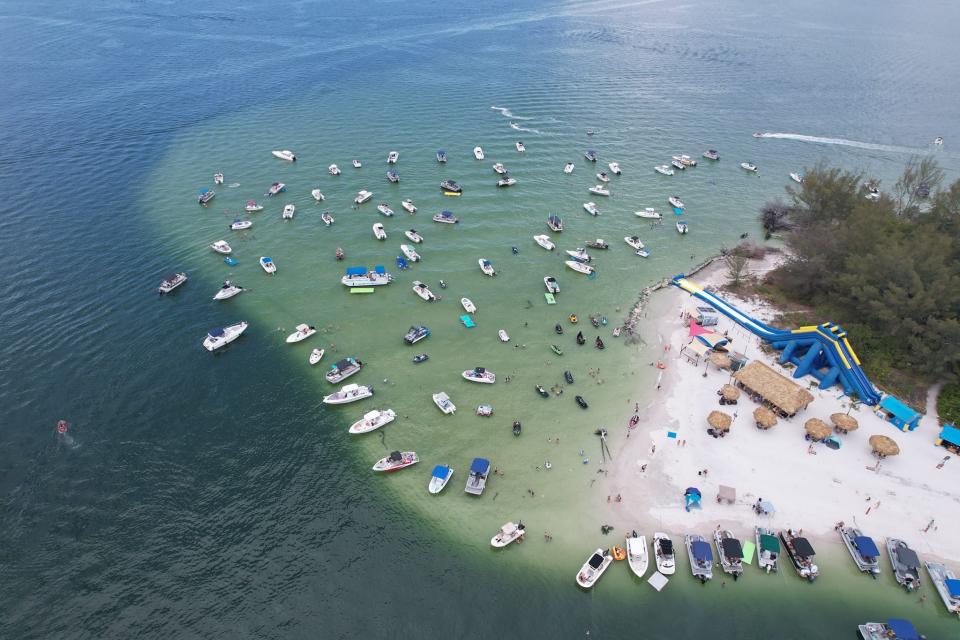 Boats float near an island in Tampa Bay that has been a popular boating destination for decades. Pine Key, also known as Beer Can Island, was listed for $14.2 million in February, 2024.