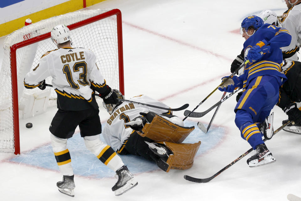 Buffalo Sabres center Tage Thompson, right, falls to the ices as he scores pasts Boston Bruins goaltender Jeremy Swayman (1) as Bruins' Charlie Coyle (13) looks on during the first period of an NHL hockey game, Saturday, Dec. 31, 2022, in Boston. (AP Photo/Mary Schwalm)