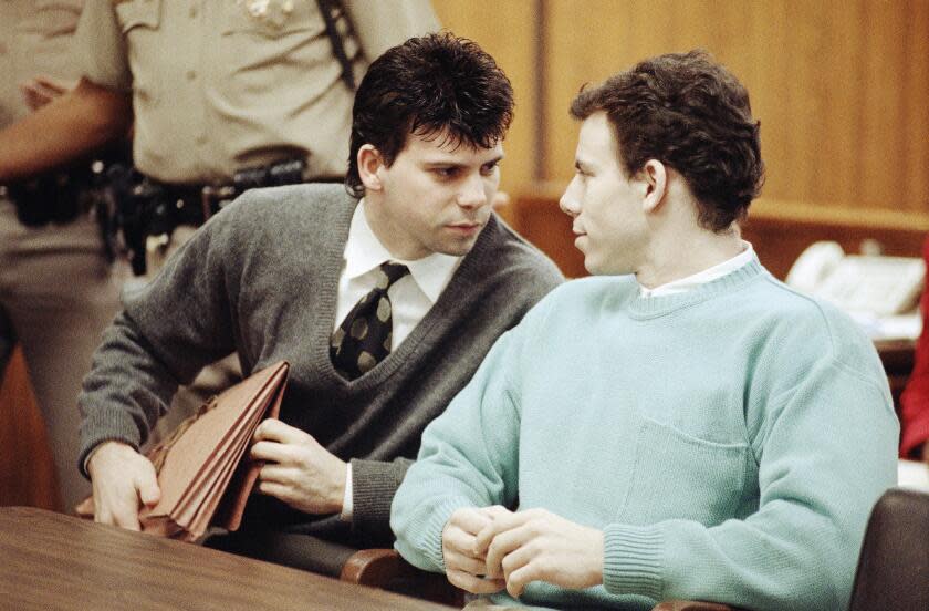 Lyle Menendez, left confers with brother Erik during a court appearance, April 2, 1991 in Beverly Hills, California. Lawyers for the brothers won another delay of a preliminary hearing while they seek a state Supreme Court opinion on whether an alleged murder confession is protected by doctor-patient privilege. (AP Photo/Kevork Djansezian)