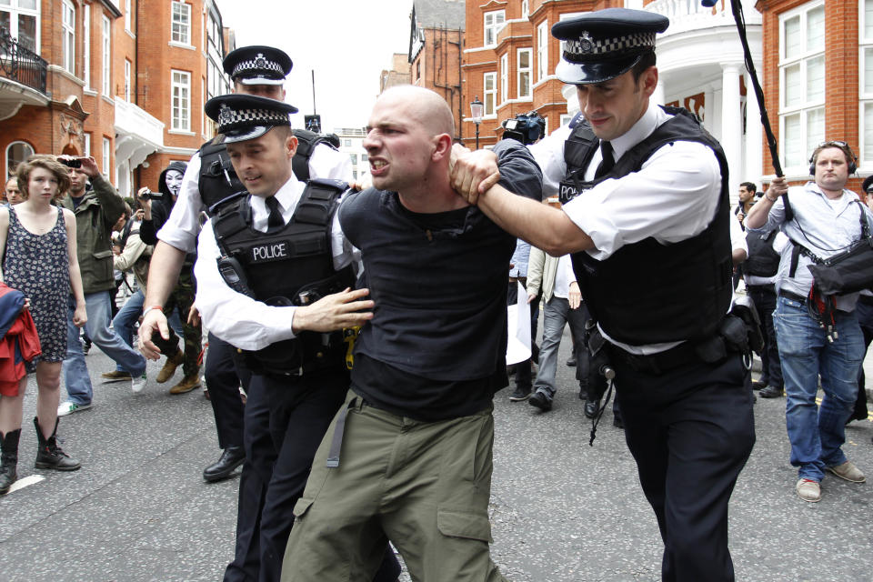 British police officers arrest a protesters in support of WikiLeaks founder Julian Assange from the front of Ecuadorian Embassy in central London, London, Thursday, Aug. 16, 2012. WikiLeaks founder Julian Assange entered the embassy in June in an attempt to gain political asylum to prevent him from being extradited to Sweden, where he faces allegations of sex crimes, which he denies. (AP Photo/Sang Tan)