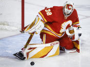 Calgary Flames goalie Dustin Wolf (32) kicks away a shot during the second period of an NHL hockey game against the San Jose Sharks Thursday, April 18, 2024, in Calgary, Alberta. (Jeff McIntosh/The Canadian Press via AP)