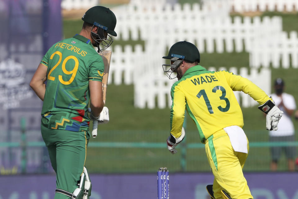 Australia's Matthew Wade, right, reacts after taking a catch to dismiss South Africa's Dwaine Pretorius, left, during the Cricket Twenty20 World Cup match between South Africa and Australia in Abu Dhabi, UAE, Saturday, Oct. 23, 2021. (AP Photo/Kamran Jebreili)