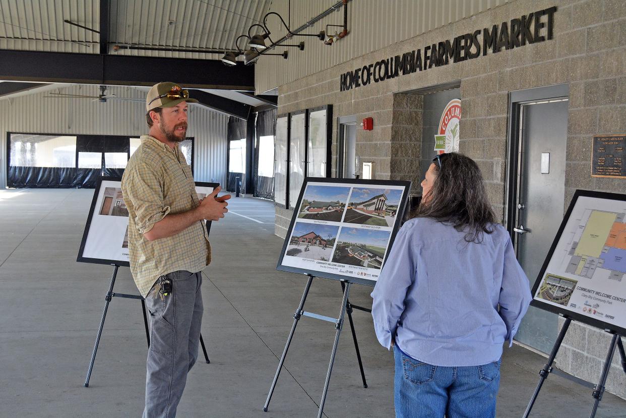Adam Saunders, Columbia Center for Urban Agriculture capital campaign director, chats with Karen Morrison on Tuesday during an open house meeting seeking feedback on welcome center plans for the Columbia Agriculture Park on West Ash Street.