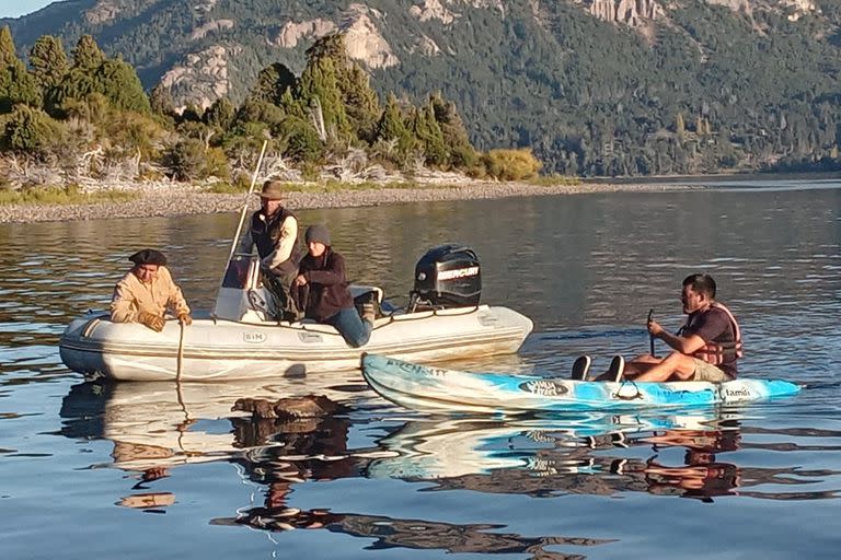 El guardaparques Diego Schro y la etóloga María Loreto Campbell (en el gomón) junto con el guía Maximiliano Solohaga (en el kayak), en la maniobra para rescatar del agua al cóndor caído