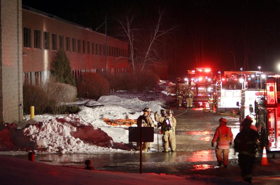 Emergency crews from several towns work an area outside the New Hampshire Ball Bearing plant after an explosion, Monday, Feb. 10, 2014 in Peterborough, N.H. At least 13 people were injured, but a company spokeswoman says none of the injuries appears to be life-threatening. (AP Photo/Jim Cole)