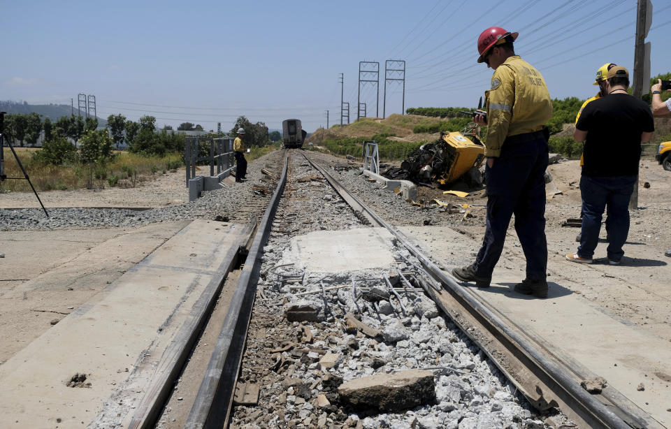 A firefighter examines part of a train track after an Amtrak train derailed in Moorpark, Calif., on Wednesday, June 28, 2023. Authorities say an Amtrak passenger train carrying 190 passengers derailed after striking a vehicle on tracks in Southern California. Only minor injuries were reported. (Dean Musgrove/The Orange County Register via AP)