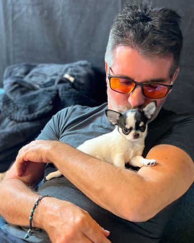 <p>Simon Cowell/Instagram</p> Simon Cowell kisses a cute black and white puppy