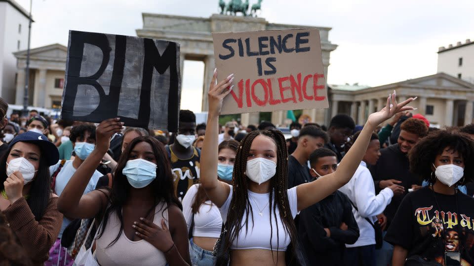 Demonstrators hold placards during a Black Lives Matter protest in front of Berlin's Brandenburg Gate in July 2021. - Christian Mang/Reuters