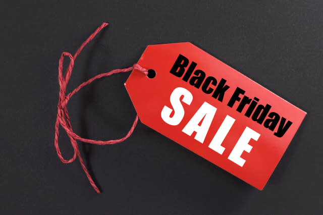 Black Friday shopping sale concept with red ticket Sale tag close up on black background.