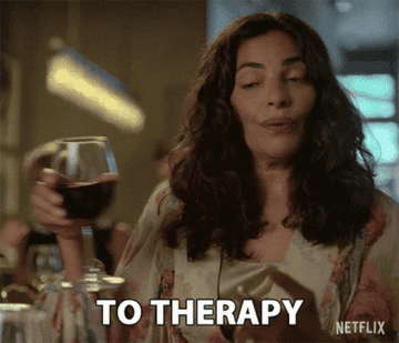 A woman making a toast "To therapy"