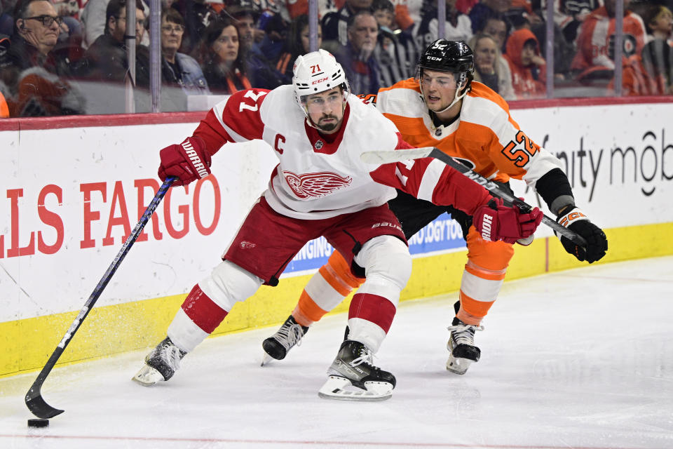 Detroit Red Wings' Dylan Larkin, left, skates the puck past the defense of Philadelphia Flyers' Tyson Foerster during the second period of an NHL hockey game, Saturday, March 25, 2023, in Philadelphia. (AP Photo/Derik Hamilton)