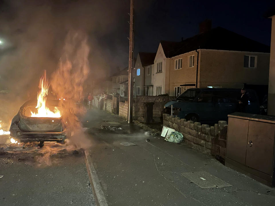 A car burns after being set on fire, on Highmead Road, Ely, in Cardiff, after a crash following a serious road traffic collision on Snowden Road in Ely in Cardiff, Tuesday, May 23, 2023. A few cars were set ablaze and objects were hurled at police after a traffic accident Monday night in the Welsh capital Cardiff grew into what officials described as “large scale disorder.” (Bronwen Weatherby/PA via AP)