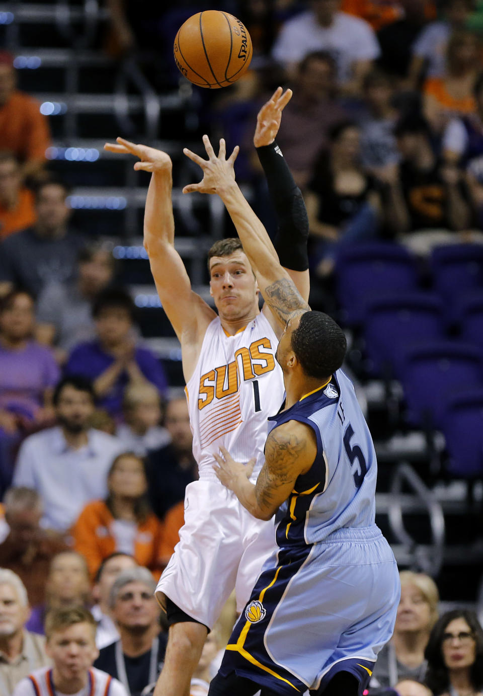 Phoenix Suns' Goran Dragic (1), of Slovenia, passes as Memphis Grizzlies' Courtney Lee (5) defends during the first half of an NBA basketball game, Monday, April 14, 2014, in Phoenix. (AP Photo/Matt York)