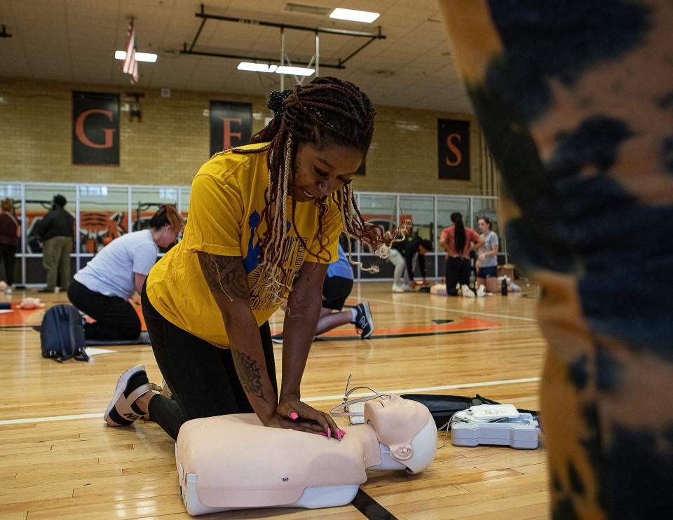 Denaye Hilton, cheer coach at Newburg Middle School, practices CPR at Fern Creek High School as part of Jefferson County Public Schools' annual fall clinic, which reviewed topics like mental health, nutrition and first-aid training. July 7, 2023