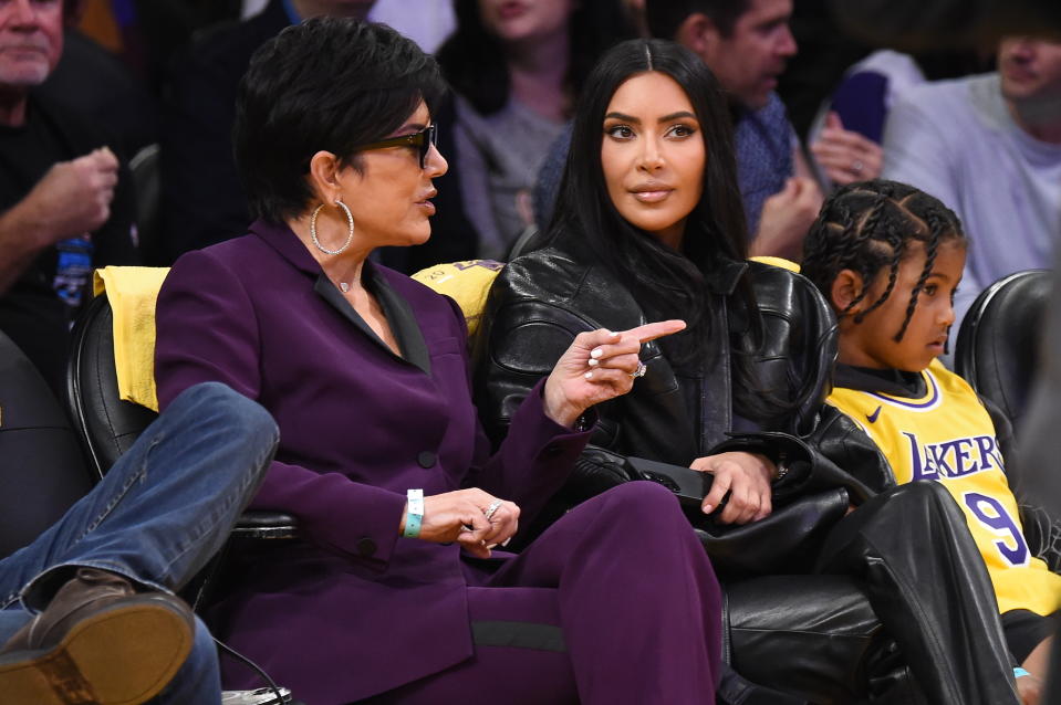 kim, north, and kris sitting at a basketball game